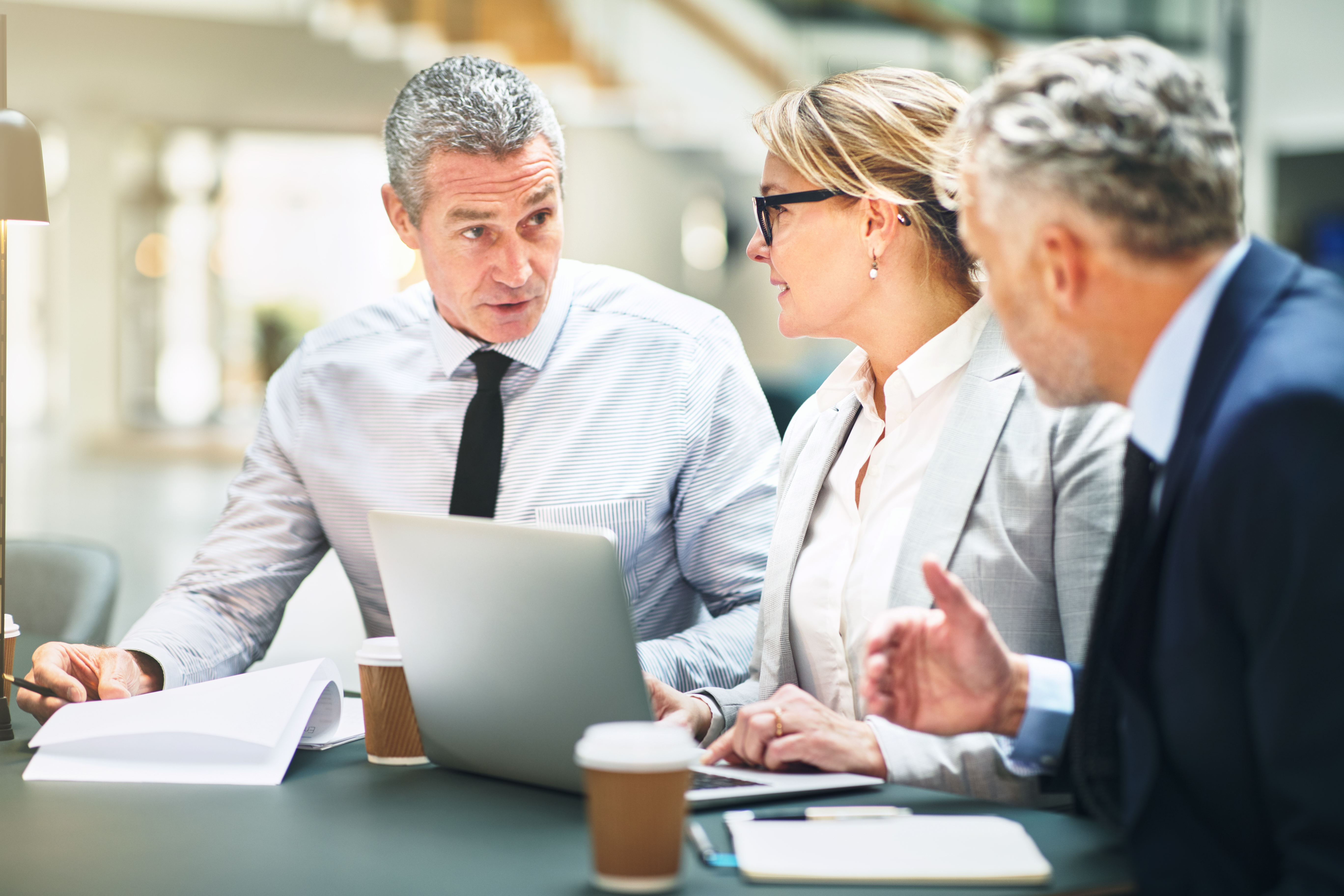 Mature corporate colleagues meeting together in a modern office